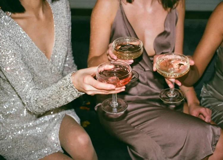 Three elegant friends celebrating in style, toasting with their glasses and radiating divine energy.