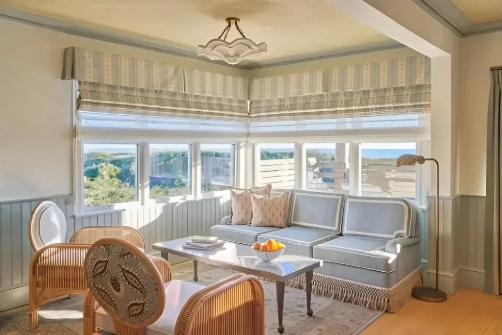 A charming and sunlit living room with two cozy chairs and a sofa, offering a breathtaking view of the sea.